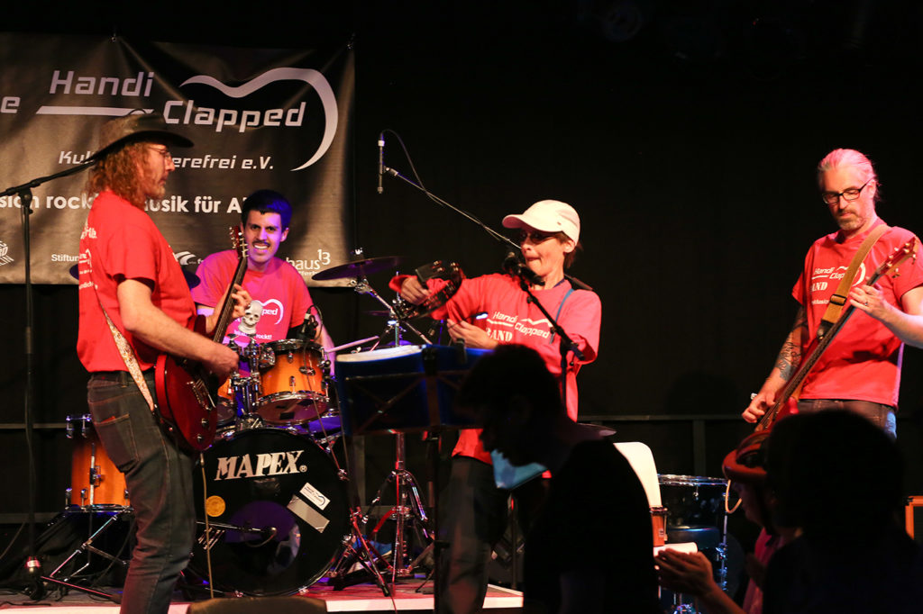 Die Handiclapped Band spielt bei einem Live Konzert auf der Bühne.