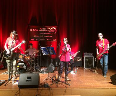 Die Handiclapped Band mit 4 Mitgliedern live auf der Bühne, in roten T-Shirts